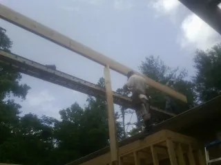 Carpenter setting a ridge beam over a new addition frame — Ice Dam Removal by Roofing Brothers in Elbing