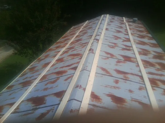 Rusted metal roof panels with new wood purlins before replacement — Storm Damage Roof Repair in Elbing by Roofing Brothers