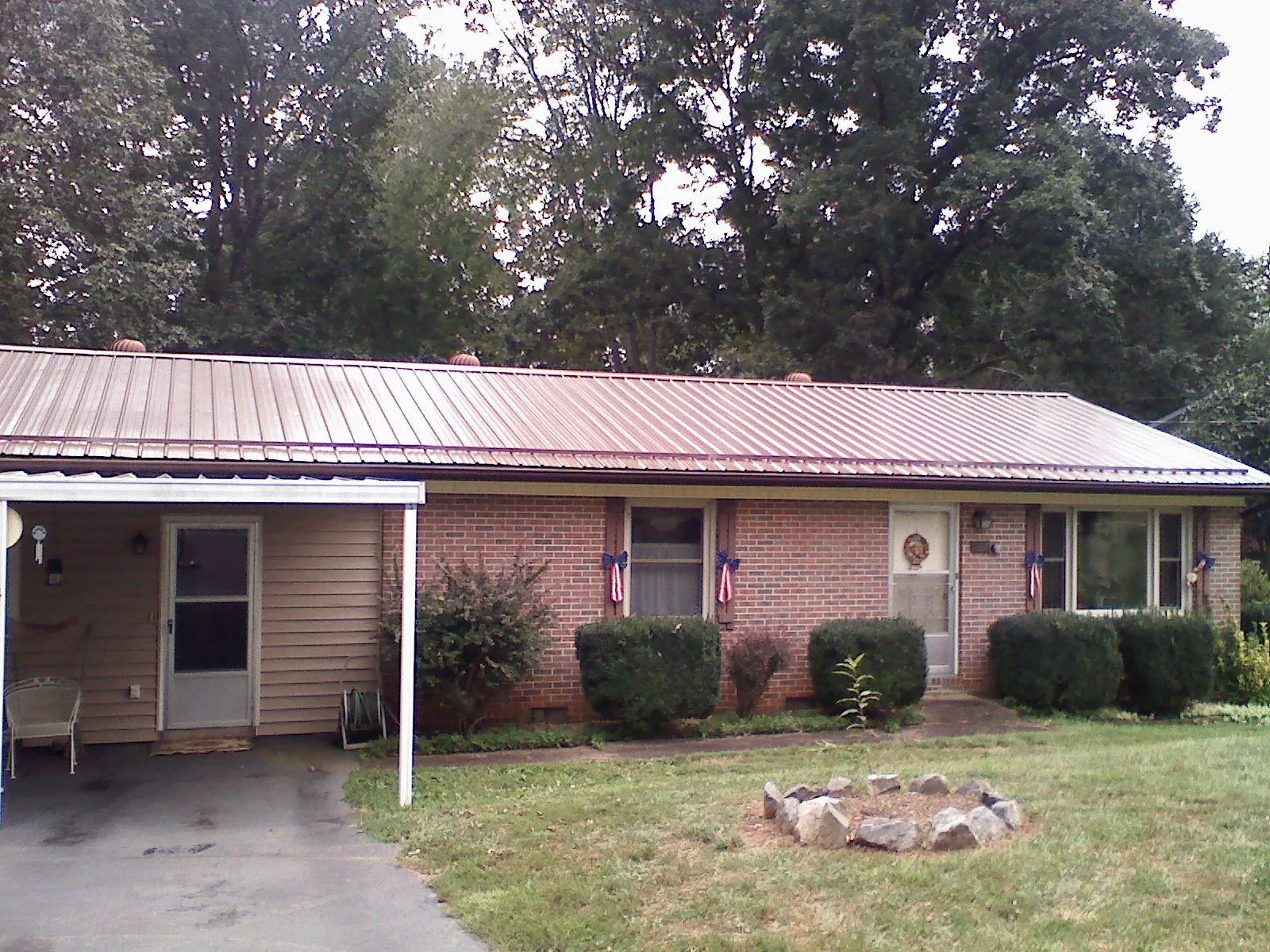 Bronze metal roof and carport on a brick ranch home — Roof Repair work by our crew in Elbing